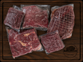 The Smoker Box from Pierce Land & Bison showing a vacuum-sealed netted bison rump roast, boneless chuck roast, brisket, and two 1 lb packages of grass-fed ground bison arranged on a dark walnut cutting board